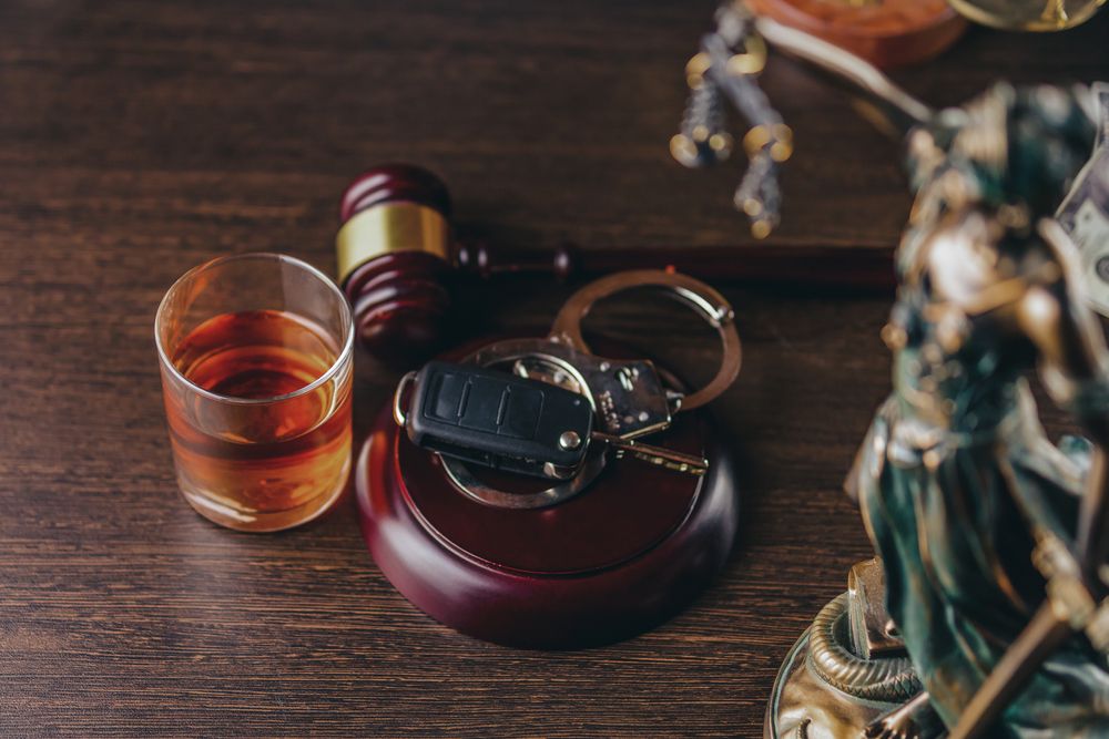 Whiskey glass, car keys, and courtroom gavel