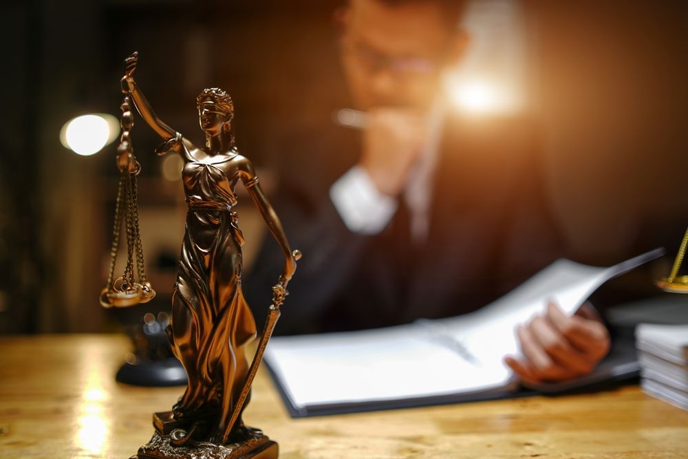 Justice statue beside a signed legal document