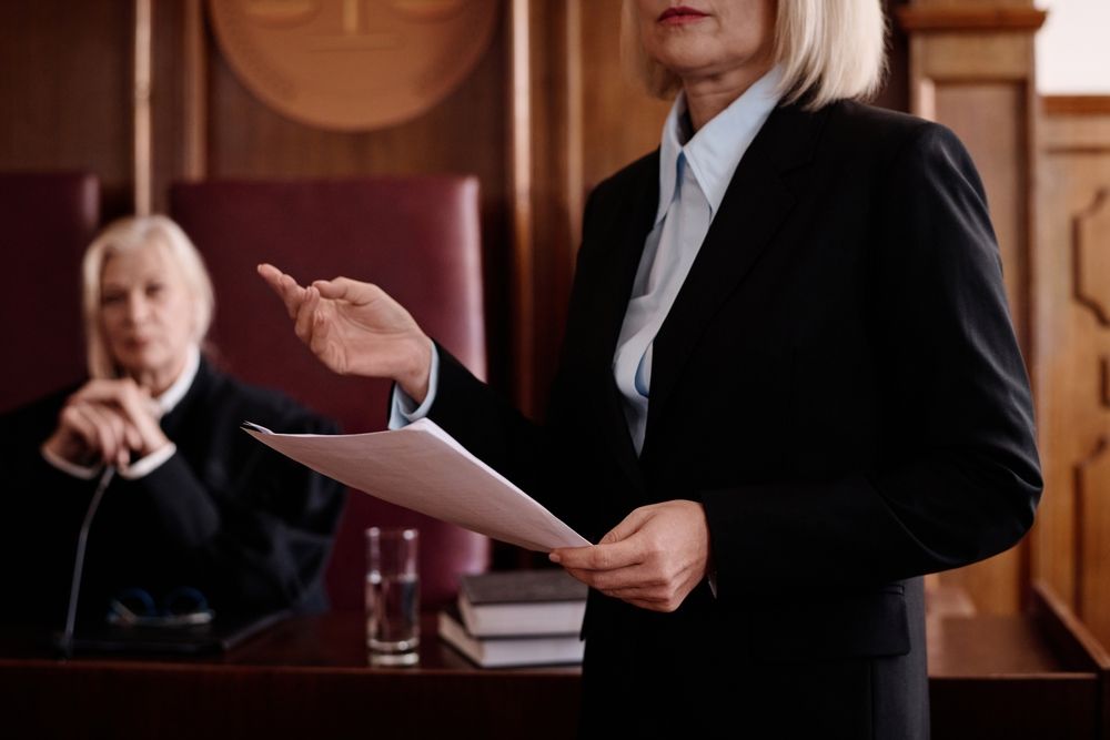 Judge addressing counsel while holding case documents