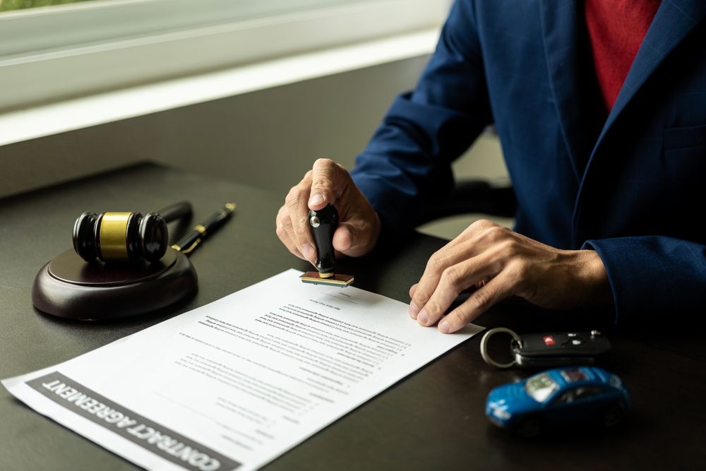 Attorney signing paperwork beside a courtroom gavel