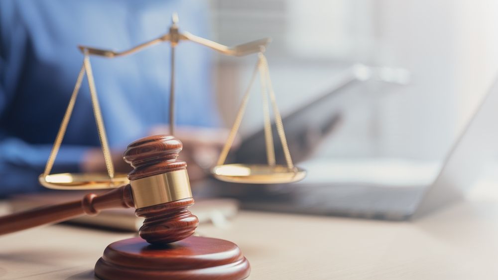 Justice scale and gavel beside an open laptop